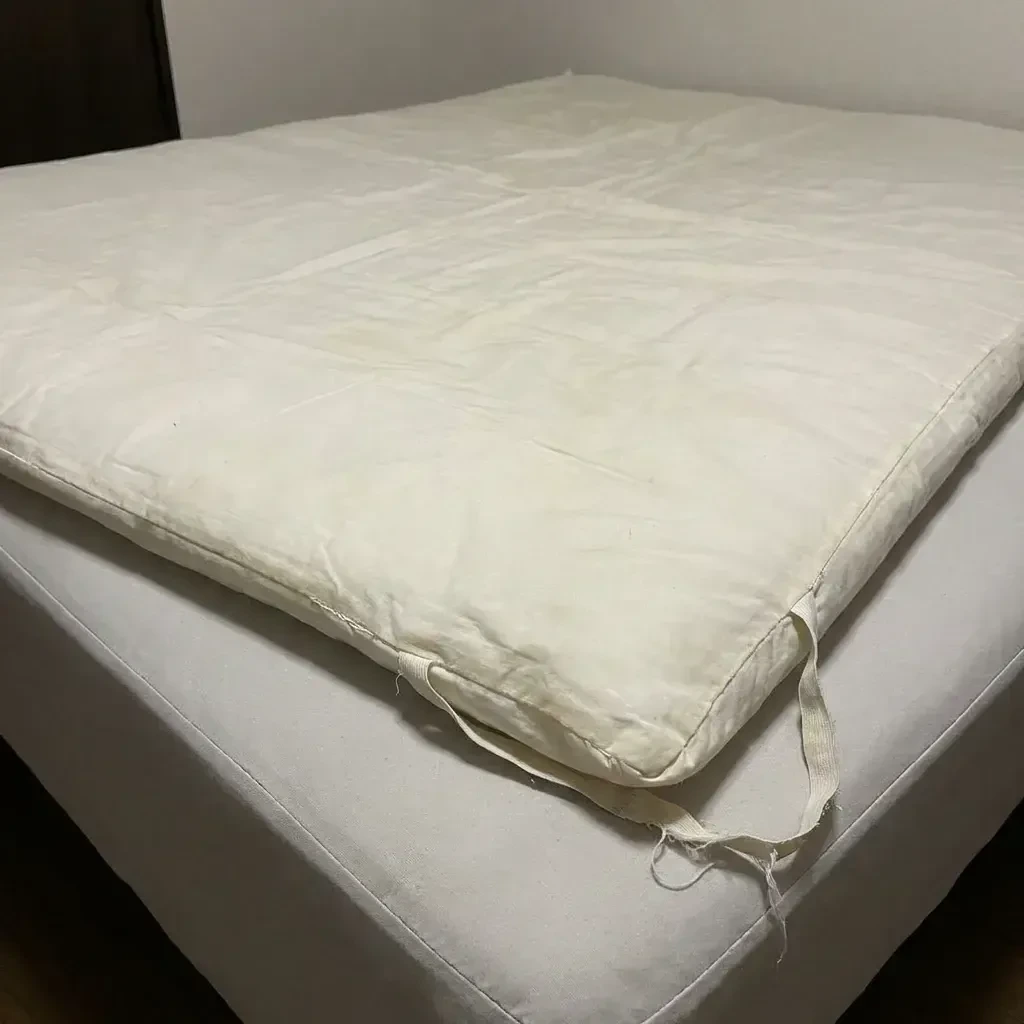 Cobertura fina comum, amarrotada sobre o colchão